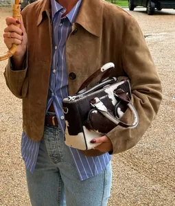 Outdoor street style featuring a brown suede jacket and cow-print texture handbag