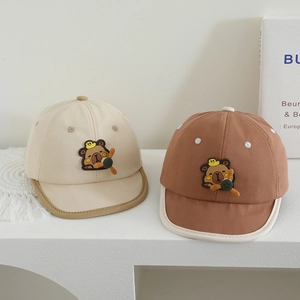 Two cute baby soft brim baseball caps with cartoon capybara patches in beige and brown.