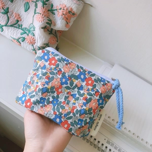Handheld floral cotton mini storage pouch with blue woven strap and zipper closure