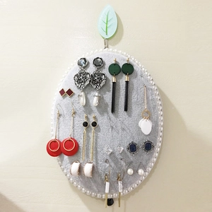 Oval grey felt jewelry organizer with pearl edge wall-mounted for earring display