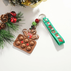 Gingerbread man pop it keychain with green wristlet and bells on festive background