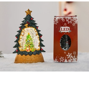 Detail of Christmas tree snow globe with LED lights and festive gift packaging