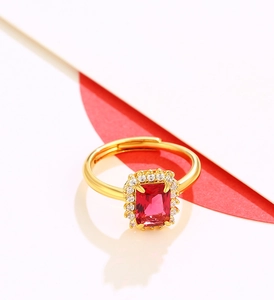 Macro shot of an adjustable gold ring with a large red rectangular gemstone and zircons