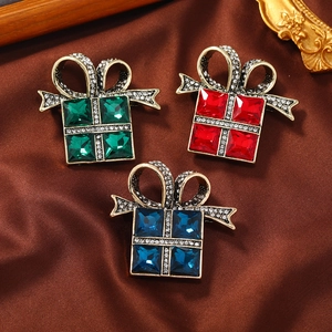 Macro detail of retro gift box brooches with emerald crystals and sparkling rhinestones