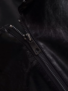 Macro shot of metallic zipper teeth on high-quality black leather jacket texture