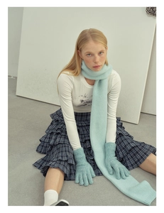 Detail showing soft light blue knitted wool blend scarf and matching five-finger gloves