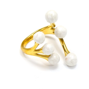 Macro detail of a 18k gold-plated branch ring with six marble-textured beads on white