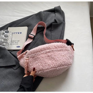 Close-up of a soft pink fuzzy waist bag featuring a textured sherpa finish and zipper detail
