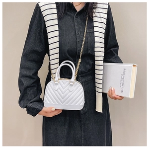 Detailed view of white jelly shell bag with V-quilted texture and gold chain strap