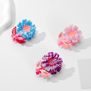 Three colorful acetate sunflower hair claws in blue, pink, and purple for women
