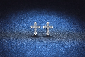 Detailed close-up of S925 sterling silver cross earrings with shimmering moissanite stones