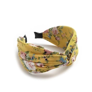 Close-up of yellow floral bow headband with pink and blue blossoms on white background