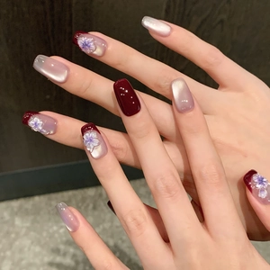 Handmade press-on nails with deep red cat eye effect and 3D purple flower pearls