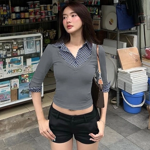 Vue détaillée du haut polo pour femme avec patchwork à carreaux et design en maille superposée