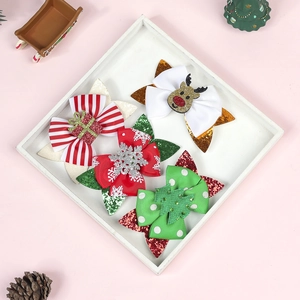 Detail of four Christmas themed glitter hair clips with reindeer and tree ornaments
