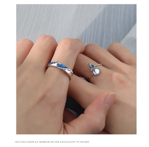Close-up of S925 silver couple rings featuring blue enamel waves and whale tail design