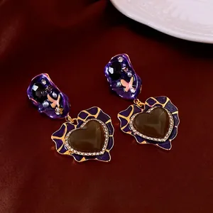 Vintage heart drop earrings with purple enamel and diamonds on dark silk fabric