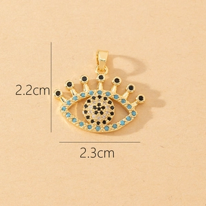 Macro view of gold Evil Eye pendant with blue and white zircon stones sized 2.3cm by 2.2cm