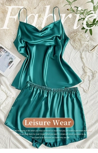 Detail of dark green satin sleepwear set with silk texture laid on white fabric background