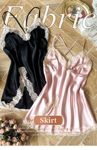 Flat lay of black and pink satin lace chemises on light wood floor with floral decor