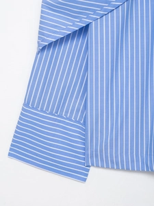 Close-up detail of blue and white striped shirt hem and cuffs on a white background