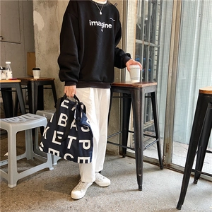 Navy blue oversized canvas tote bag styled with casual black sweatshirt and white pants