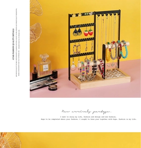 Detail view of the black metal jewelry stand with wooden base for necklaces and rings