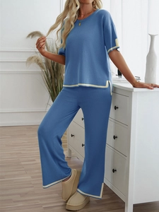 Detailed close-up of blue knit two-piece set with yellow trim on a model in a bright room
