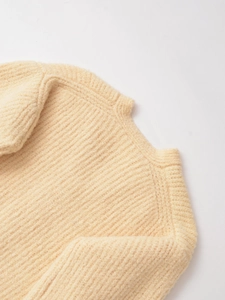 Vue détaillée du gilet en maille à col en V avec texture pelucheuse et mailles côtelées