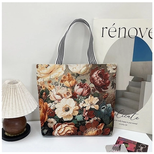 Artistic detail of vintage tote bag with floral 3D embroidery and striped handle