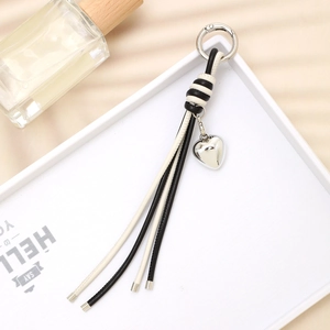 Creative braided leather keychain with black and white fringe and silver heart charm