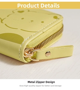 Close-up of golden zipper and fine stitching on yellow leather wallet with bear pattern
