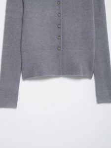 Dettaglio del cardigan grigio con bottoni a sfera in metallo e bordo a costine