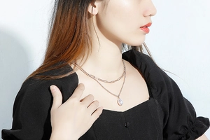 Double-layered silver necklace with paperclip chain and baroque pearl pendant on model