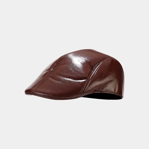 Detailed view of glossy red-brown PU leather texture and stitching on the beret cap