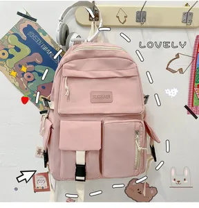 Detail view of the pink multi-pocket nylon backpack showing zippers and buckle straps