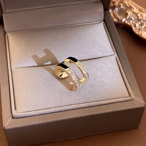 Detail view of double-layer gold ear cuff with black enamel and micro-set cubic zirconia