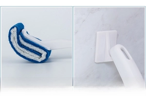 Close-up of upturned toilet brush head and wall-mounted handle with hanging hole