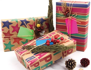 Flat lay of colorful Happy Birthday kraft paper set with twine and botanical accents