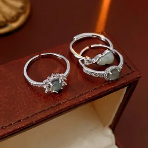 Three-piece silver open ring set with green stones and zircons on leather display
