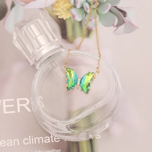 Elegant gold butterfly necklace featuring a green gradient crystal pendant with zircons