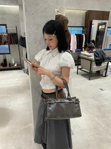 Dettaglio di una borsa Boston grigio scuro vintage con cinturini decorativi e fibbia