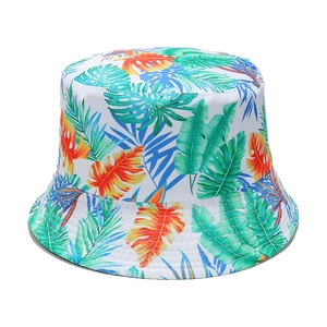 Detail of floral bucket hat with green palm leaves and tropical monstera prints