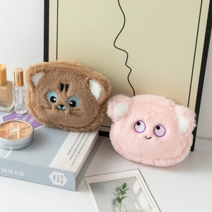 Dettaglio di simpatici portamonete in peluche con facce ricamate e morbida pelliccia