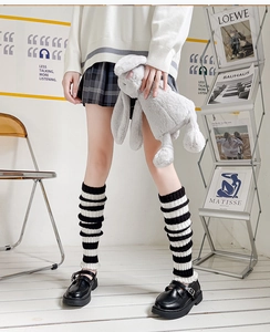 Detail of striped knitted leg warmers in JK style with frilled edges and soft texture