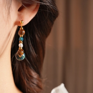 Close-up of vintage beaded earrings with tiger eye stone, crystal and white pearls