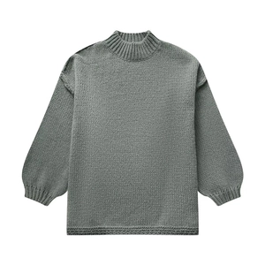 Détail d'un pull gris en grosse maille avec col montant et manches lanterne bouffantes