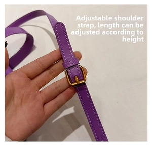 Detail of adjustable purple leather shoulder strap with golden buckle and white stitching