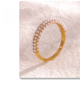 Detailed close-up of 18K gold plated ring with three rows of micro pearls on stone