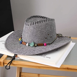 Détail du chapeau de paille gris avec ruban en pierres et œillets d'aération latéraux